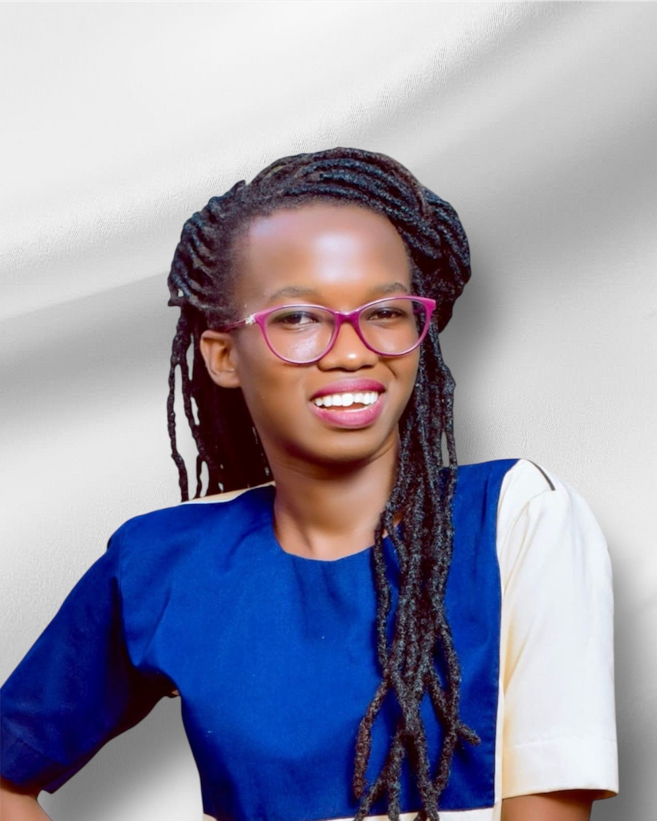 Person with long braided hair wearing a blue and white top, posing against a white background.